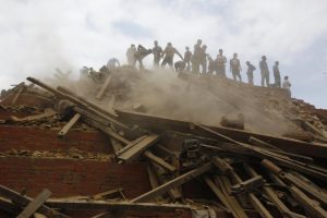 Volunteers help remove debris of a building that collapsed at Durbar Square, after an earthquake in Kathmandu, Nepal, Saturday, April 25, 2015. (AP Photo/ Niranjan Shrestha)