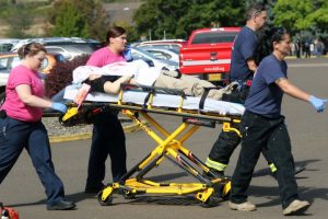 Authorities carry a shooting victim away from the scene after a gunman opened fire at Umpqua Community College in Roseburg, Ore., Thursday, Oct. 1, 2015.  (Mike Sullivan/Roseburg News-Review via AP)