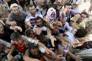 Displaced Iraqis from the Yazidi community gather for humanitarian aid at the Syria-Iraq border at Feeshkhabour border point, northern Iraq, Sunday, Aug. 10, 2014. Kurdish authorities at the border believe some 45,000 Yazidis passed the river crossing in the past week and thousands more are still stranded in the mountains. (AP Photo/ Khalid Mohammed) ORG XMIT: BKM114