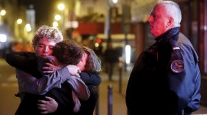 People hug on the street near the Bataclan concert hall following fatal attacks in Paris, France, November 14, 2015. Gunmen and bombers attacked busy restaurants, bars and a concert hall at locations around Paris on Friday evening, killing dozens of people in what a shaken French President described as an unprecedented terrorist attack. REUTERS/Christian Hartmann