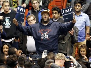 Protester tears up a Trump sign.