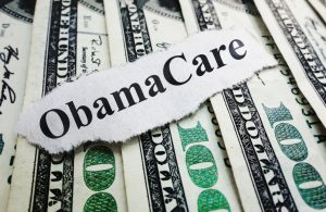 Closeup of an Obamacare newspaper headline on cash