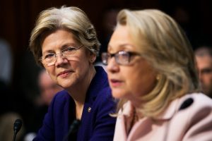 Senator Elizabeth Warren, a Democrat from Massachusetts, left, looks on as U.S. Secretary of State Hillary Clinton speaks during a Senate Foreign Relations Committee nomination hearing in Washington, D.C., U.S., on Thursday, Jan. 24, 2013. Senator John Kerry stressed the need to prevent Iran from acquiring nuclear weapons. He described the "immediate, dangerous challenges" facing the nation as he seeks confirmation to become secretary of state. Photographer: Andrew Harrer/Bloomberg via Getty Images