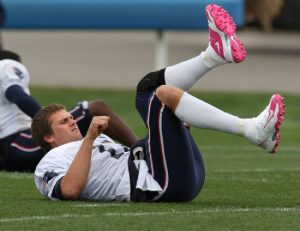 (100109 Foxboro, MA) New England Patriots quarterback Tom Brady stretched out with a pair of pink cleats on at practice at Gillette Stadium on Thursday, October 1, 2009. Staff Photo by Matthew West.