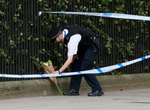  A police officer places flowers in Russell Square, Jonathan Brady/PA Wire.