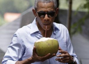 Obama drinks from a fresh coconut in Laos.