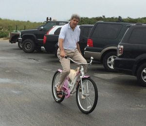 080614 - Nantucket - John Kerry pedaling a pink bicycle on Nantucket.He is riding his bike, out at Jetties Beach on Nantucket, with his dog in tow. Please credit tocourtesy of "Nantucket Native Lando from his Instagram; landogramms"