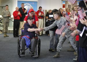 HONORFLIGHT, NWS, PORTER, 1. - Harvey Spaulding, 88, and a World War II veteran shakes hands with a member of the 128th refueling unit as he enters the concourse. Eight veterans were cheered on as they get ready to board the latest Honor Flight to Washington D.C. to view the war memorials. This flight was the first one to include Viet Nam vets. October 4, 2013. GARY PORTER/GPORTER@JOURNALSENTINEL.COM